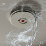 Illustration of a smoke alarm sounding off in a smoky room